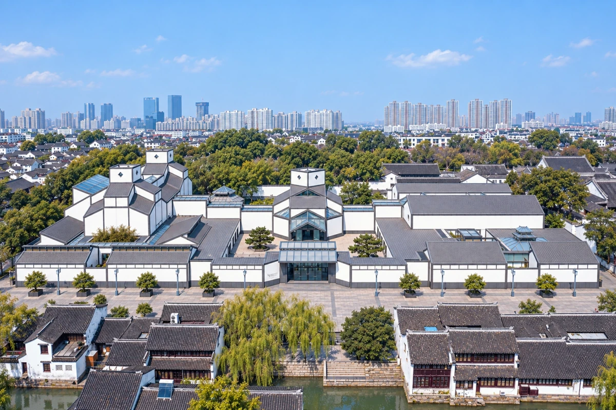 AI视觉演绎:苏州博物馆本馆入口轴线全景,正面高位观察传统入口、白墙灰屋与几何屋顶。