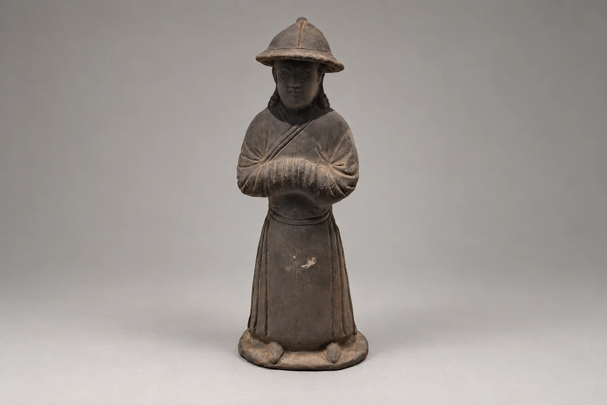 元代侍者俑：衣袍、站姿和手部位置构成侍者形象，小型陶塑将人物的动作固定在有限体量中。
